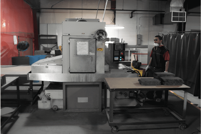 Worker operating industrial machinery in a factory setting.