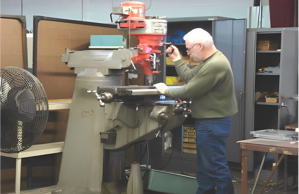 Man operating a milling machine in a workshop.